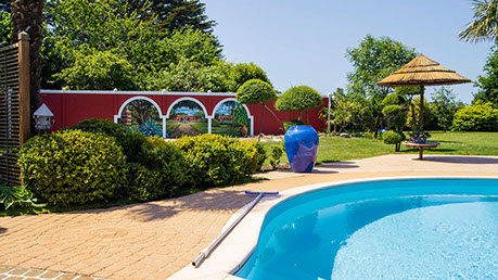 Habillage en rompe-l’œil des abords d'une piscine privative extérieur, avec jardin exotique à Quimper dans le Finistère en Bretagne.