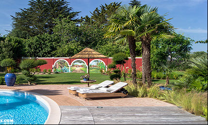 Habillage trompe-l’œil des abords d'une piscine privative dans un jardin exotique à Quimper dans le Finistère en Bretagne.