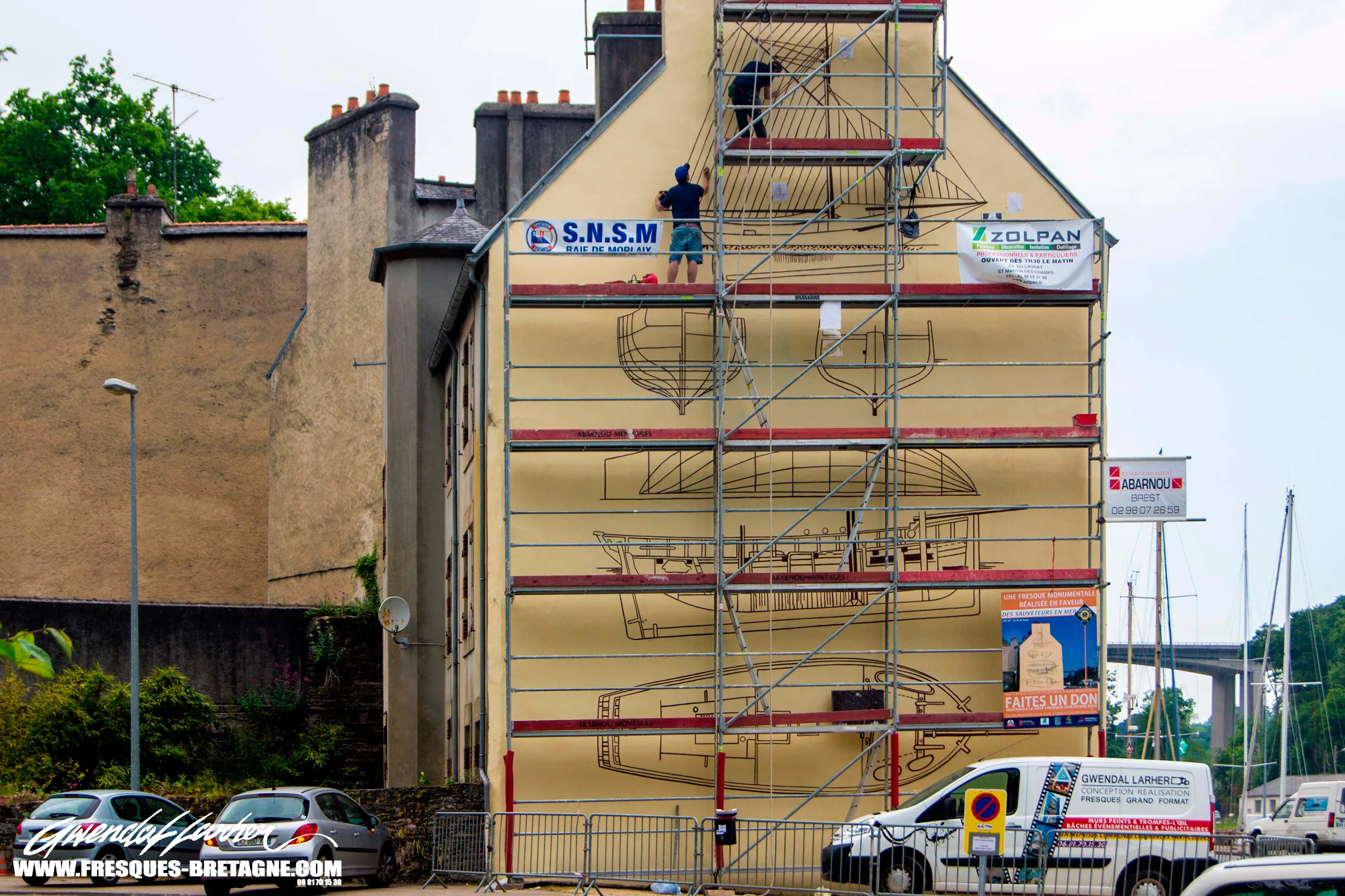 Gwendal Larher, fresquiste et artiste muraliste, devant une fresque monumentale à Morlaix.