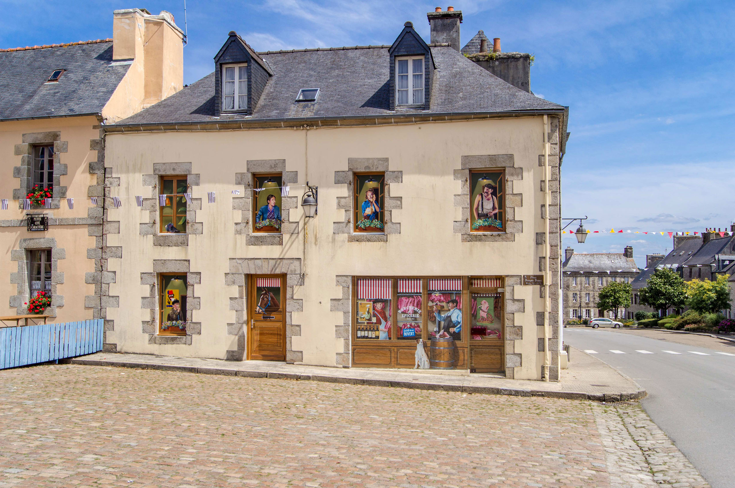 cette image représente  une oeuvre de street art peinte en trompe-l'oeil et réaliser sur un pignon façe au présidial à Guerlesquin.