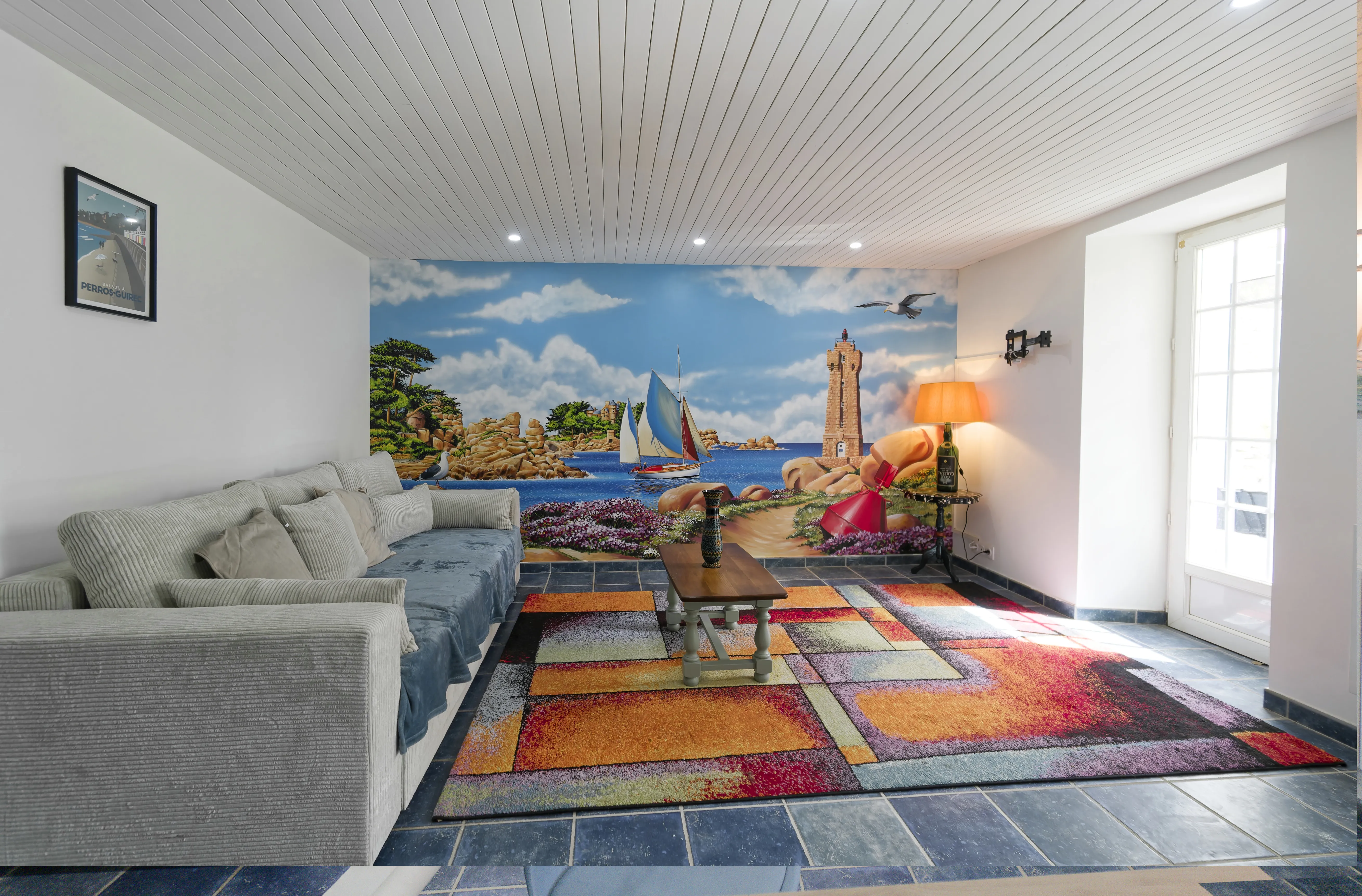 Peinture de marine panoramique, phare de Ploumanac'h, salon d'un gîte après réalisation.